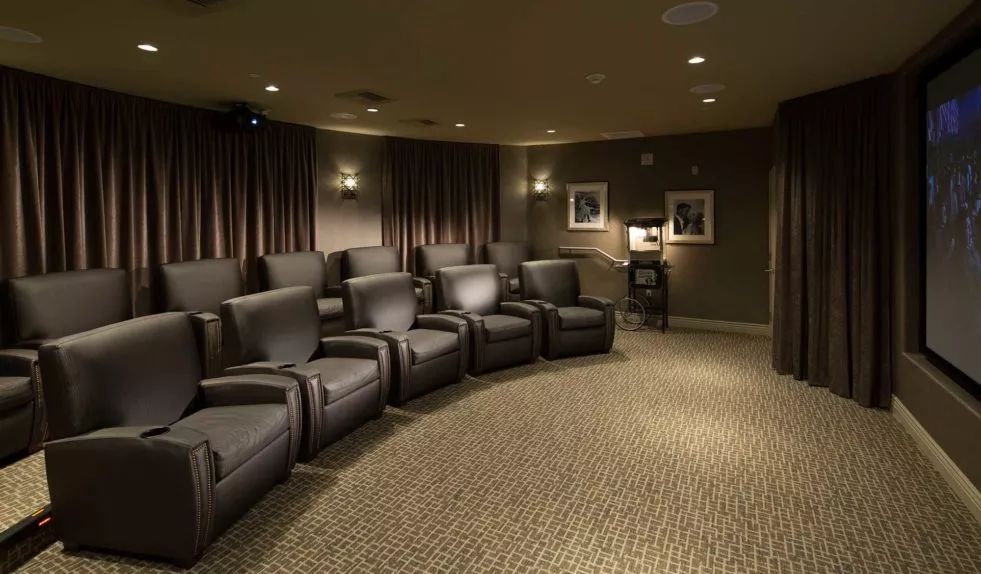 A luxurious home theater room with comfortable recliner seating.