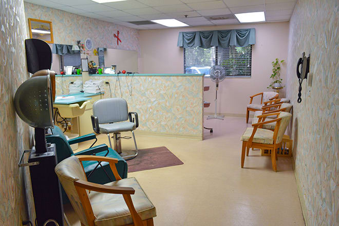 An empty waiting room with rows of chairs and a reception desk.