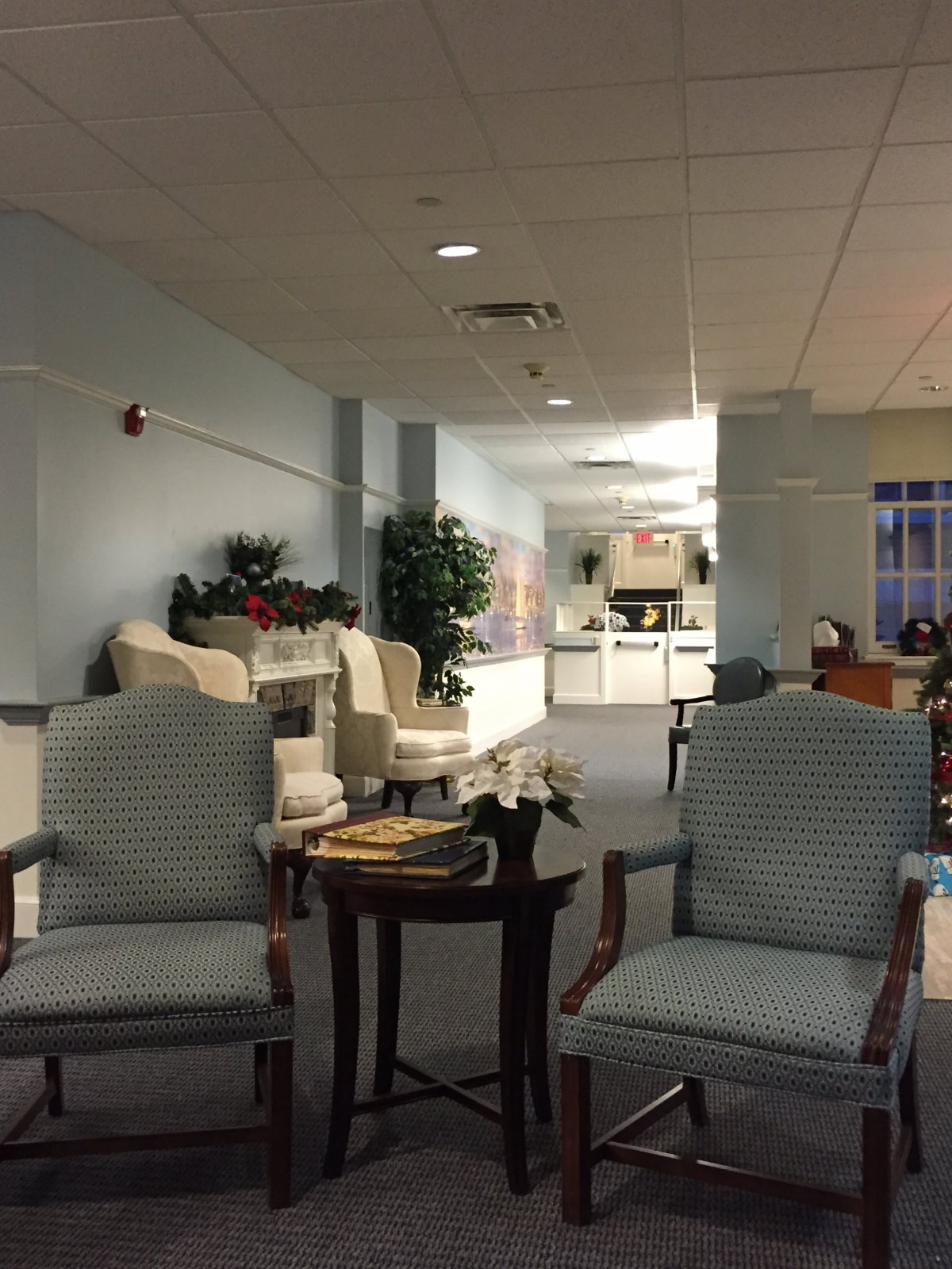 A cozy waiting room with chairs and a small table, featuring comfortable decor.