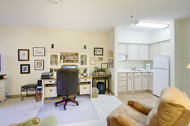 A cozy home office setup with an adjacent kitchenette.