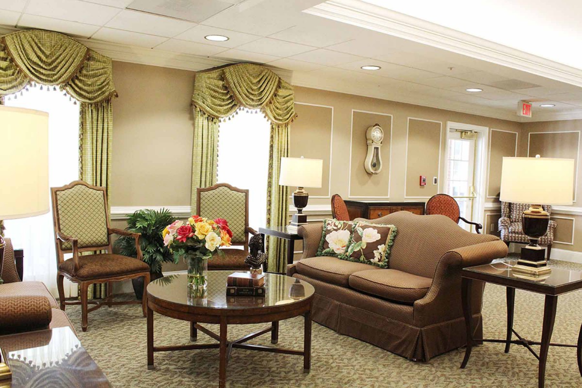 A well-furnished living room with a sofa, chairs, and decorative elements.