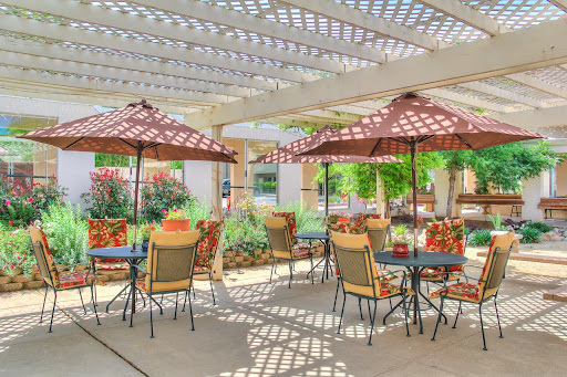 A beautiful outdoor patio area with comfortable seating and shaded umbrellas, perfect for enjoying a sunny day.