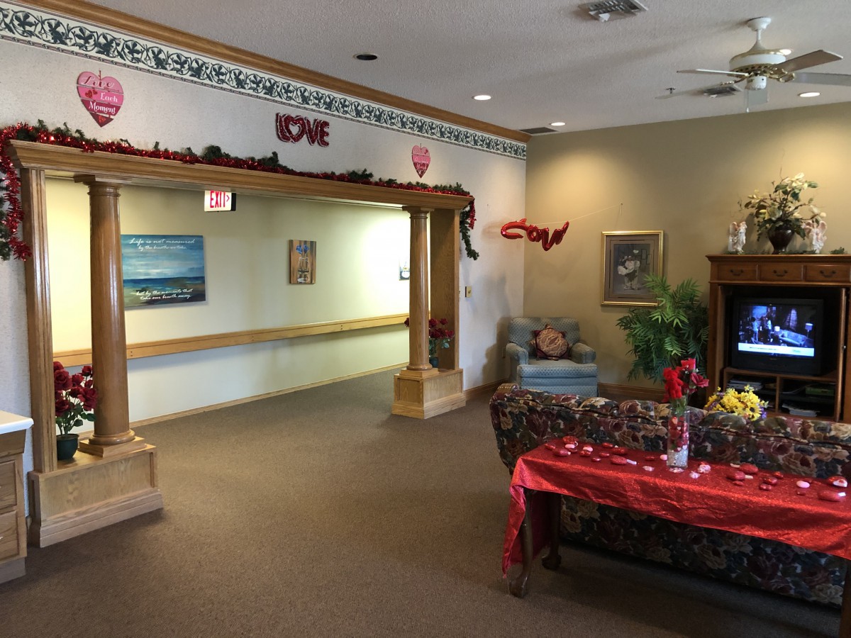 A cozy living room with seasonal decorations, featuring a table set for an event and a comfortable seating area.