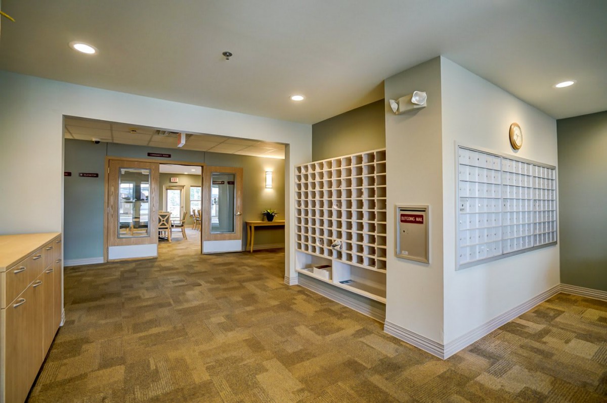 Modern apartment lobby with mailboxes and entrance area.