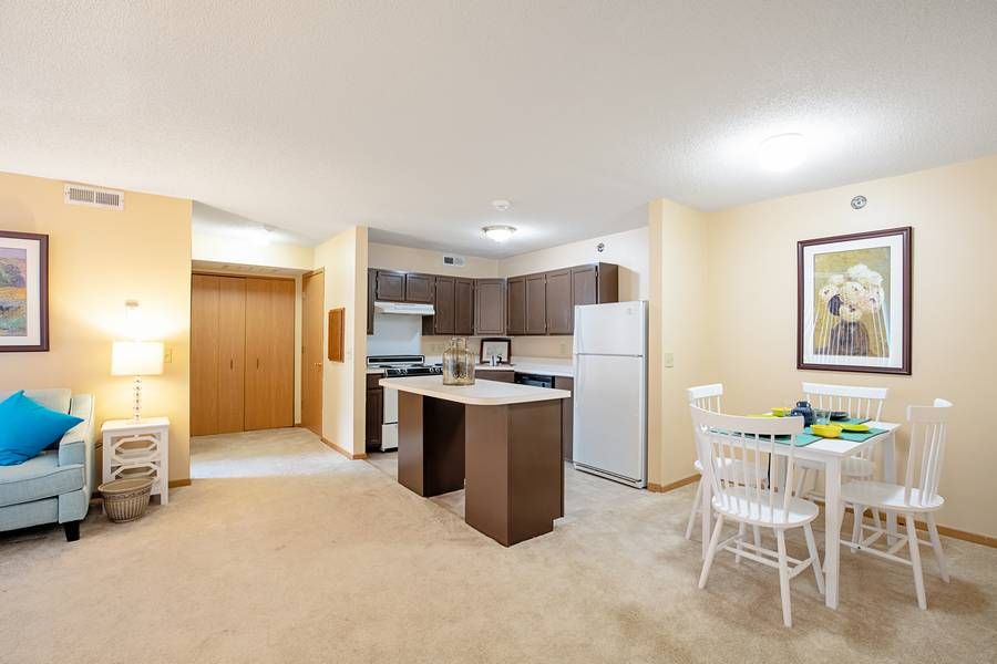 A modern apartment interior with an open-layout kitchen and dining area.