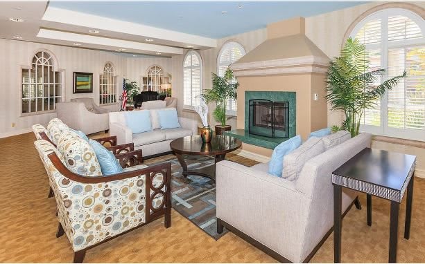 A cozy and elegantly decorated living room featuring comfortable seating and a fireplace.