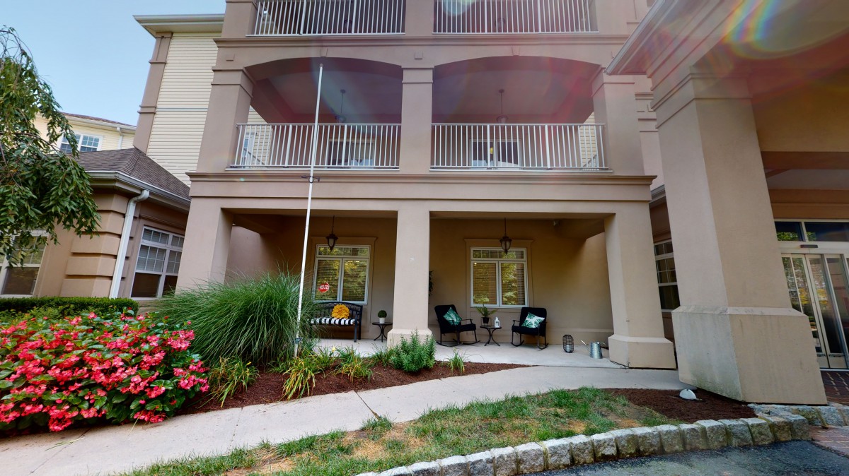 An apartment building with balconies and a garden patio area.