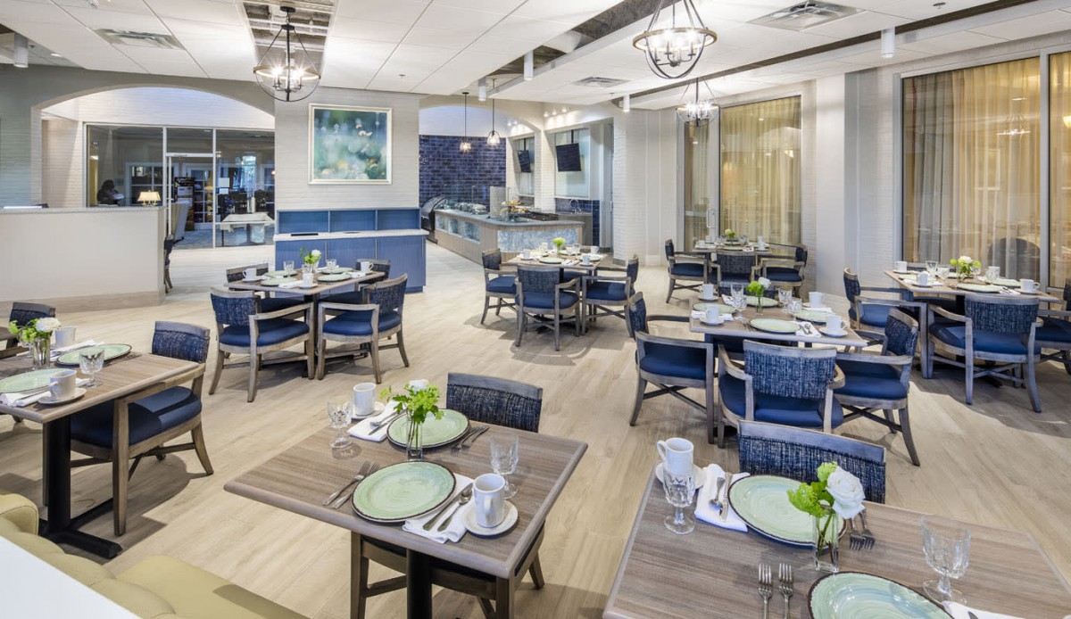 A beautifully set restaurant dining area with neatly arranged tables and chairs, creating an elegant ambiance.