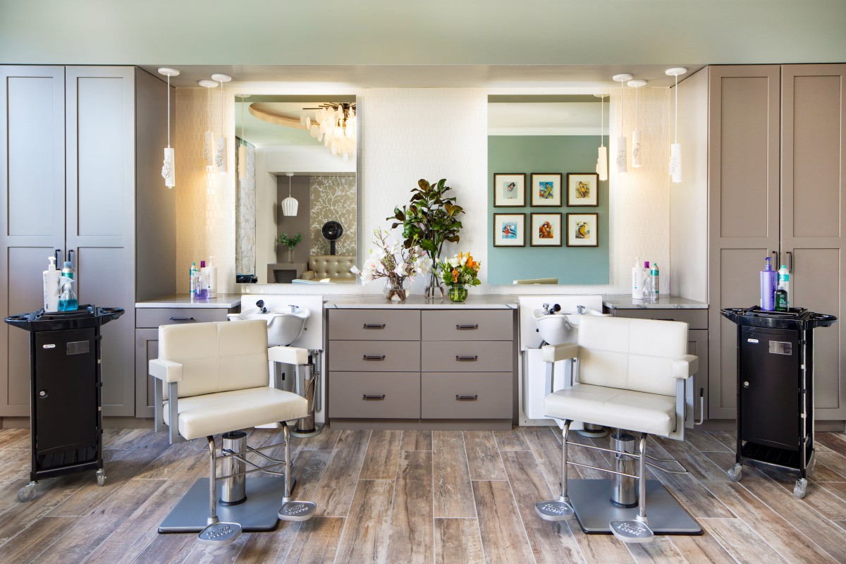 A modern salon interior with stylish barber chairs and large mirrors.