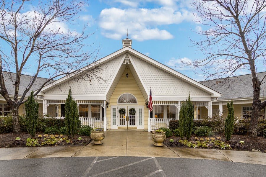 A symmetrical view of a charming building with a peaked roof and arched entrance.