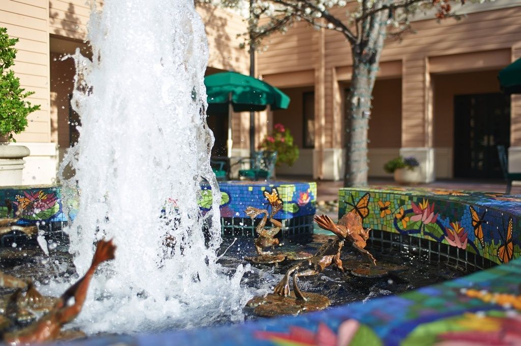 A charming fountain featuring duck statues in an outdoor public space.