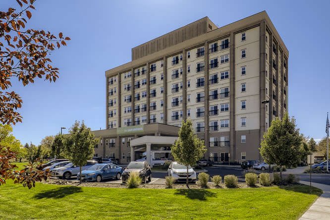 A multi-story medical facility with a parking lot and landscaped grounds.