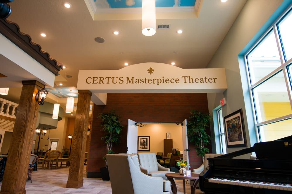Interior view of a theater lobby with comfortable seating and decorative elements.