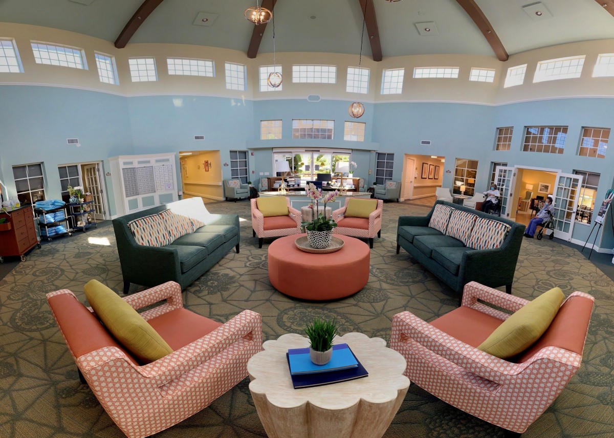 A spacious and well-decorated living room with comfortable seating arranged around coffee tables, creating a cozy and inviting atmosphere.