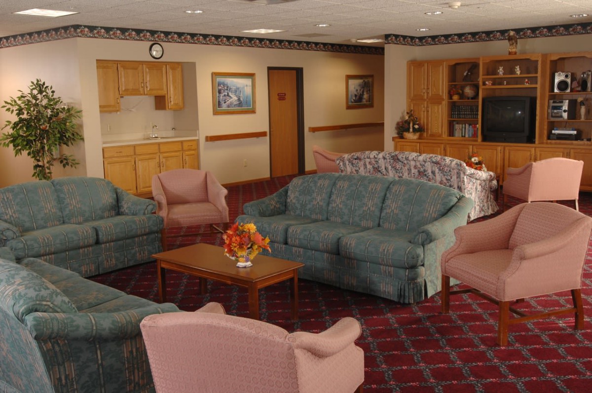 A cozy living room with comfortable sofas and armchairs arranged around a wooden coffee table.