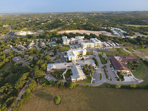 Aerial view of a residential area showcasing buildings surrounded by lush greenery.