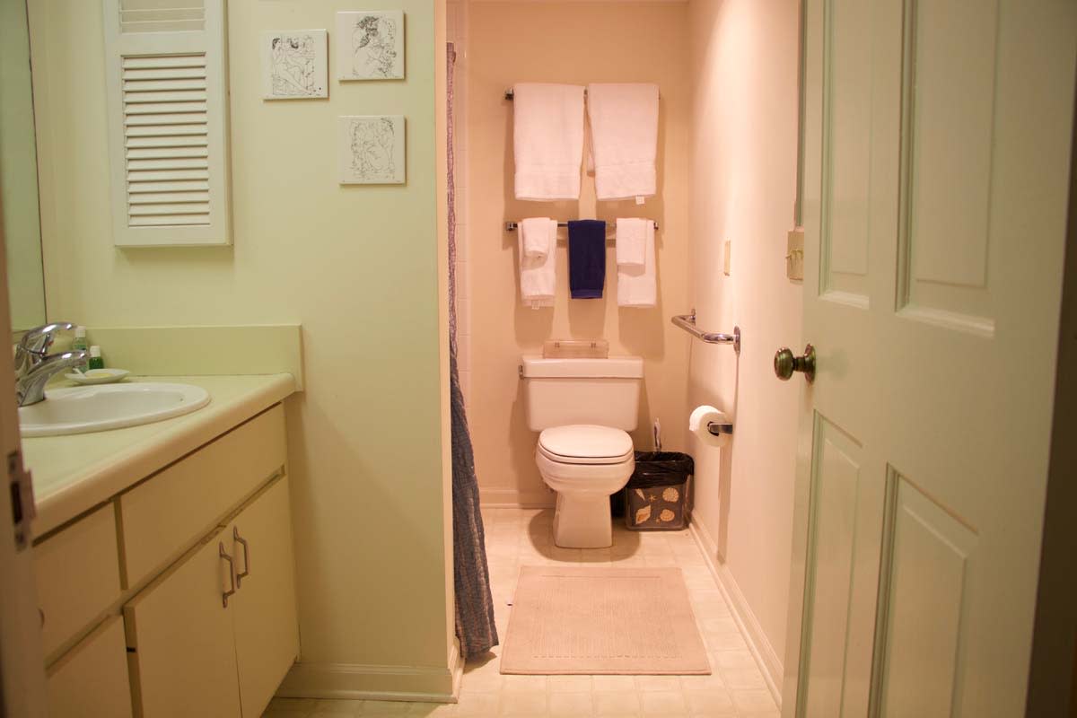 A neatly organized bathroom with a toilet, sink, and towels.