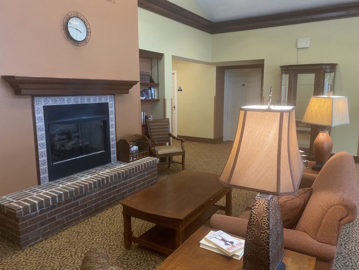 A cozy living room interior featuring a fireplace, comfortable seating, and warm lighting.