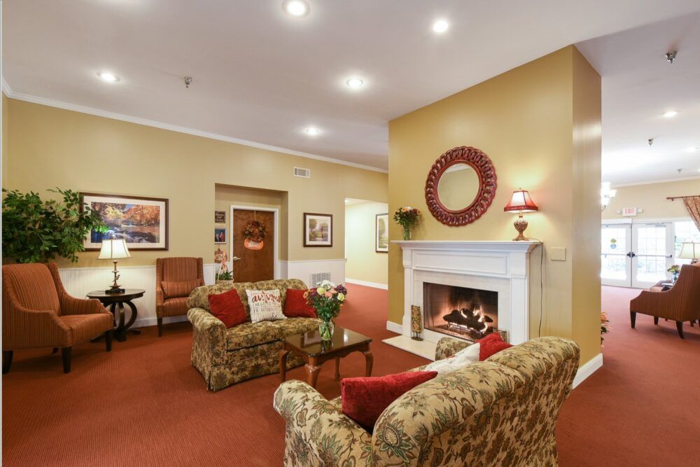 A cozy living room featuring a warm fireplace, patterned sofas, and elegant decor.