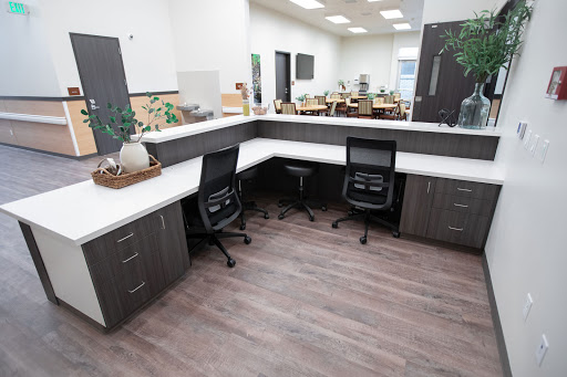 A modern office workspace featuring a corner desk setup with ergonomic chairs and a contemporary design.