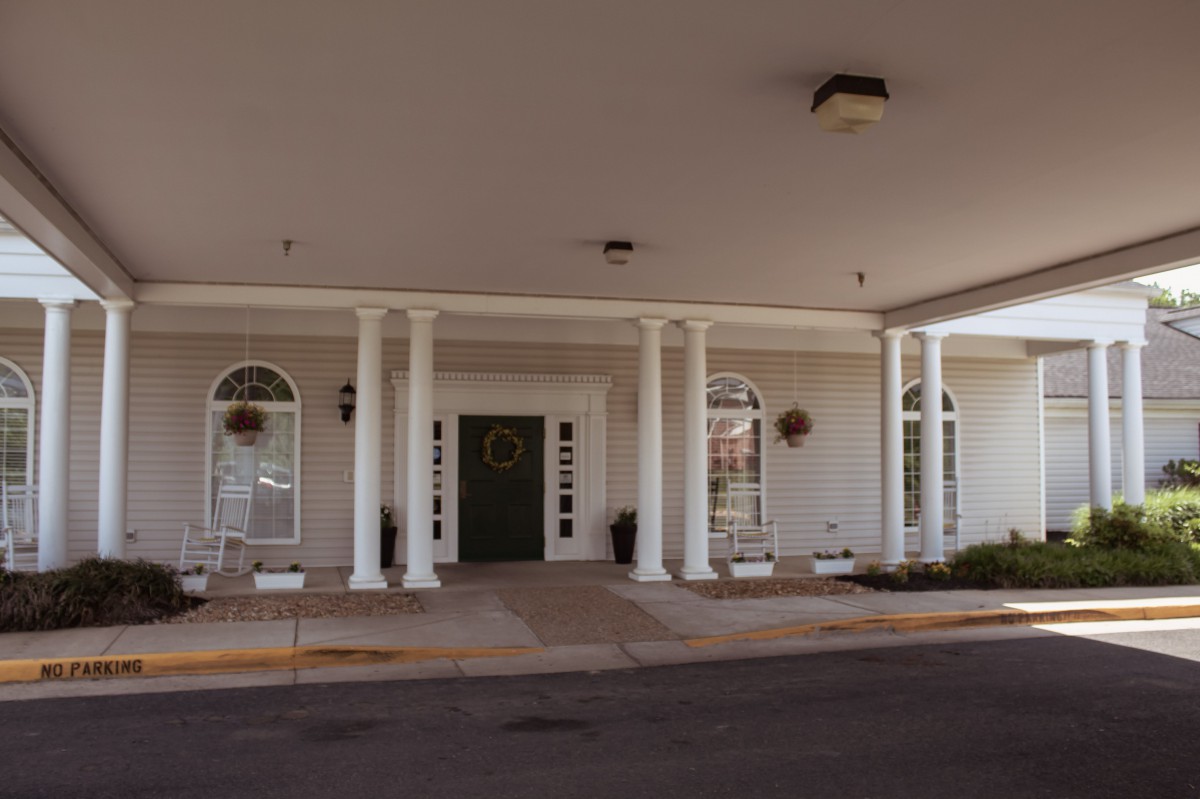 The entrance of a building featuring arched windows and decorative columns.