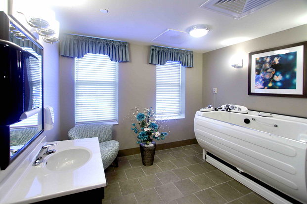 A well-lit bathroom interior with a bathtub, sink, and floral decor.