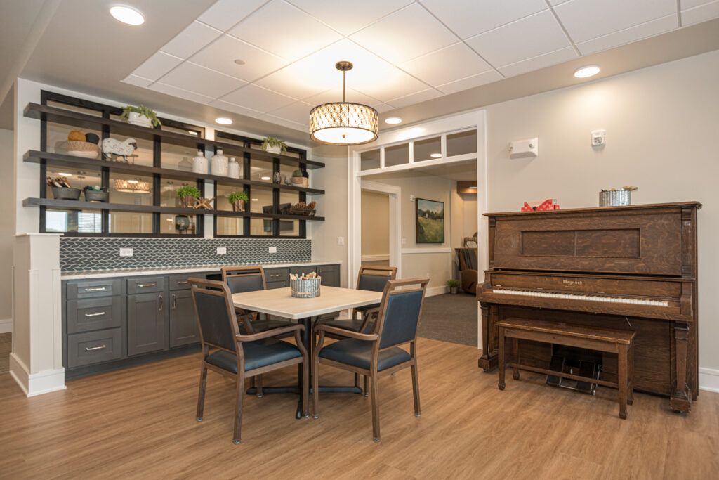 A cozy dining area featuring a table with chairs, a piano, and elegant decor.