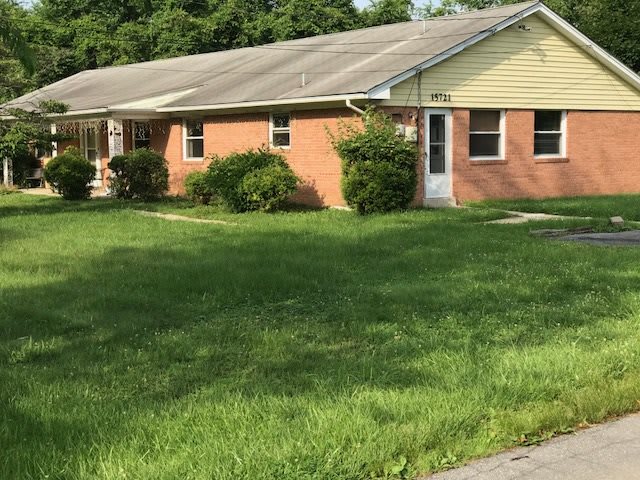 A single-story brick house with a well-maintained lawn.
