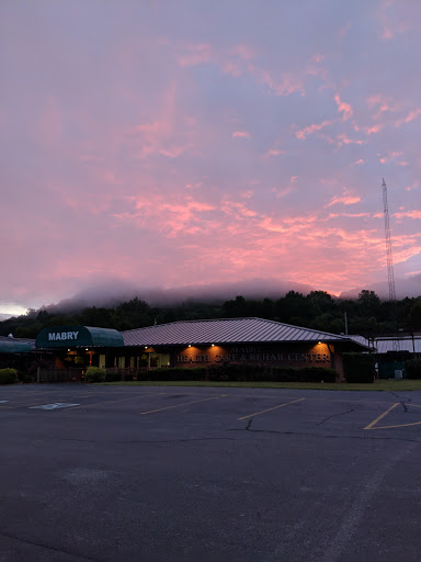 A serene sunset casts a warm glow over the building and surrounding landscape.