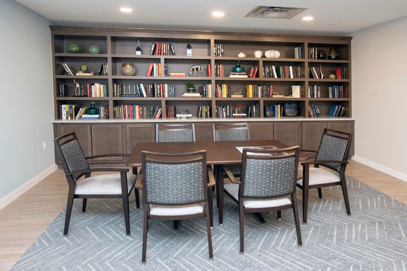 A meeting room with bookshelves lining the walls and a table surrounded by chairs.