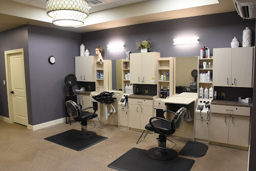 A modern hair salon featuring stylish chairs, mirrors, and a well-organized display of beauty products.