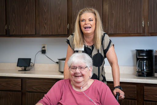 A joyful moment shared between a caregiver and a senior resident.