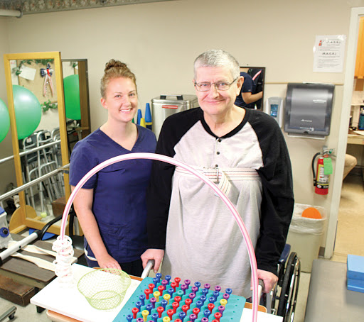 A therapist and a patient engage in a rehabilitation activity together, focusing on wellness and support.