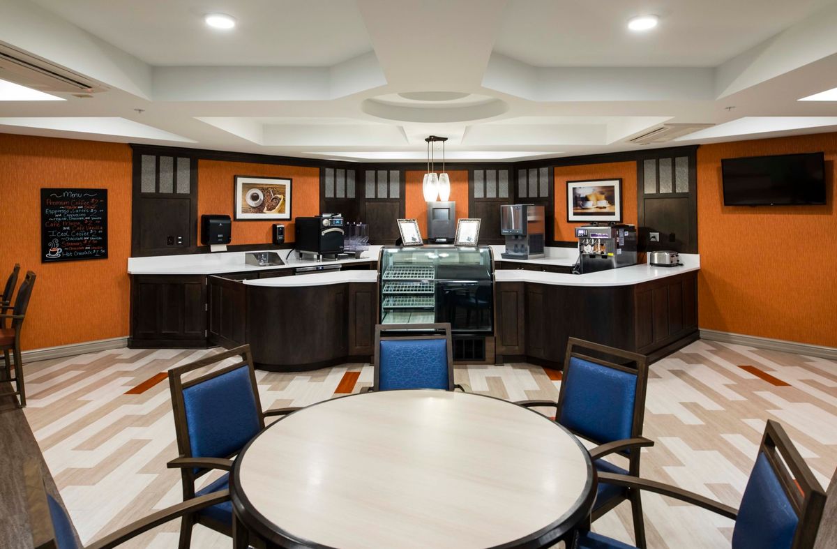 A modern hotel lobby with a reception desk and seating area.