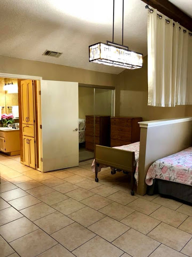 A spacious bedroom featuring a comfortable layout with wooden furniture and ample lighting.