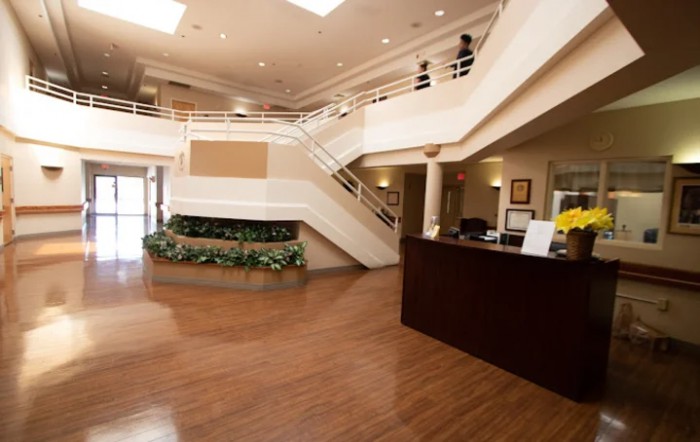 A modern lobby area with a reception desk and open staircase.