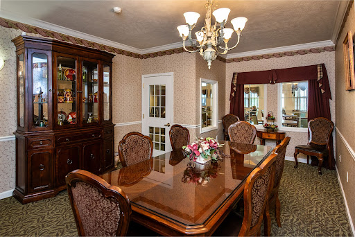 An elegantly designed dining room featuring a wooden table surrounded by ornate chairs and a stunning chandelier.