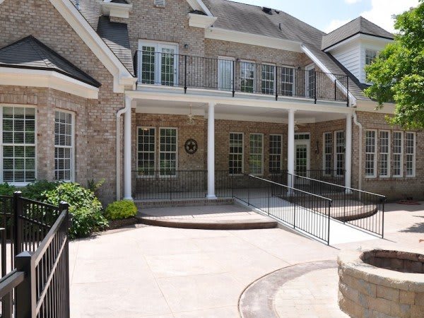 A two-story brick house with a balcony and ramp access.