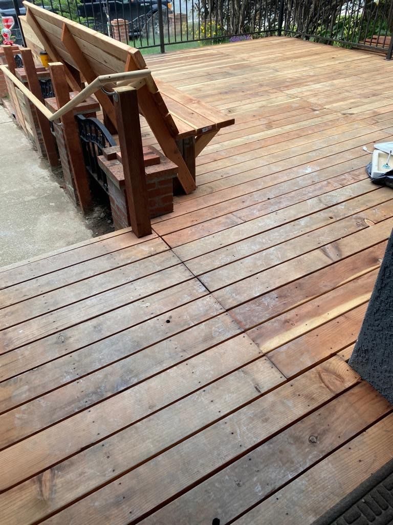 A wooden deck with stairs leading off, showcasing outdoor construction.