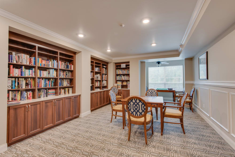 Cozy library space with bookshelves, a reading table, and chairs.