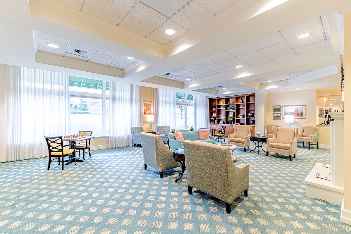 A modern and bright lounge area with comfortable seating and large windows.