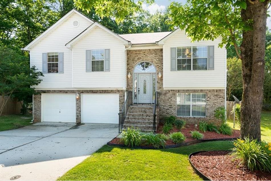 A charming two-story suburban house with well-maintained landscaping.