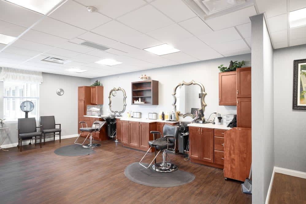 A modern hair salon interior with styling stations and wooden cabinets.