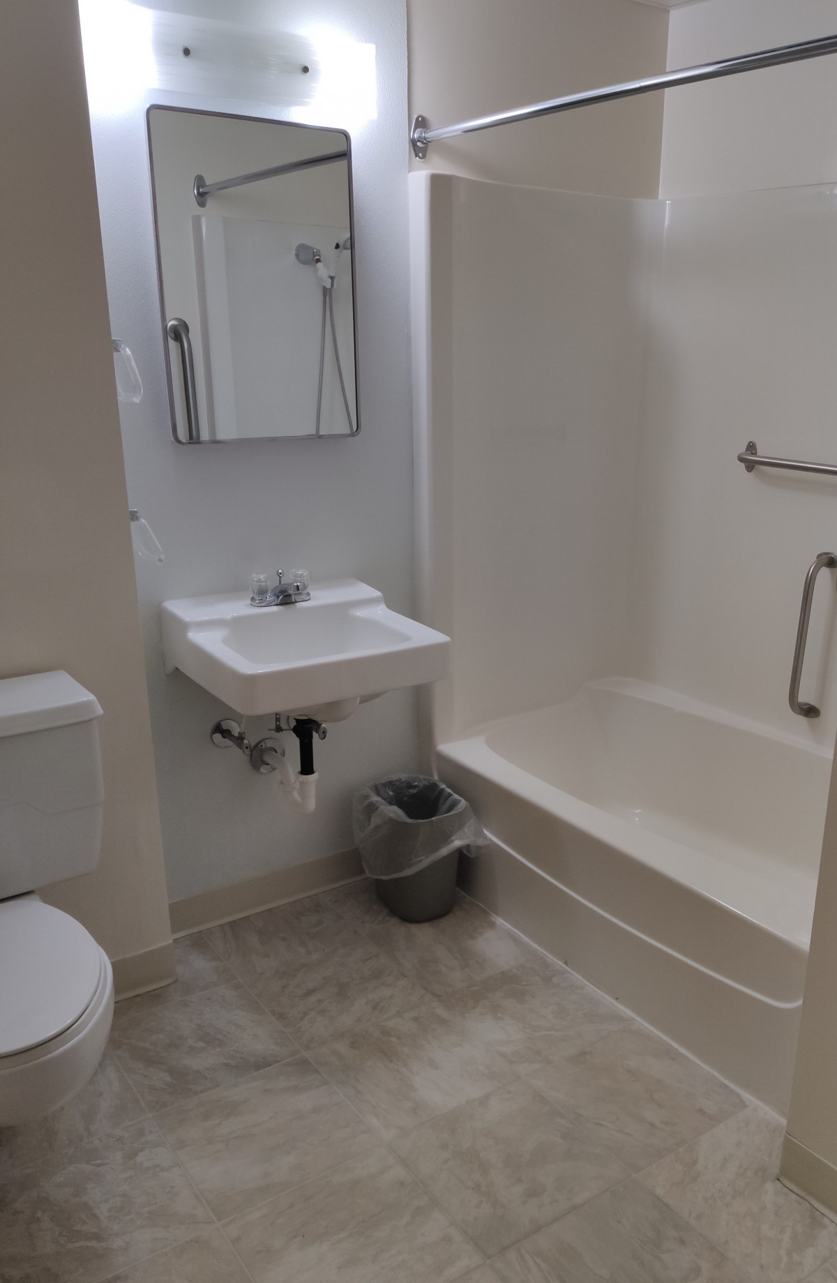 A modern bathroom with a toilet, sink, and bathtub.