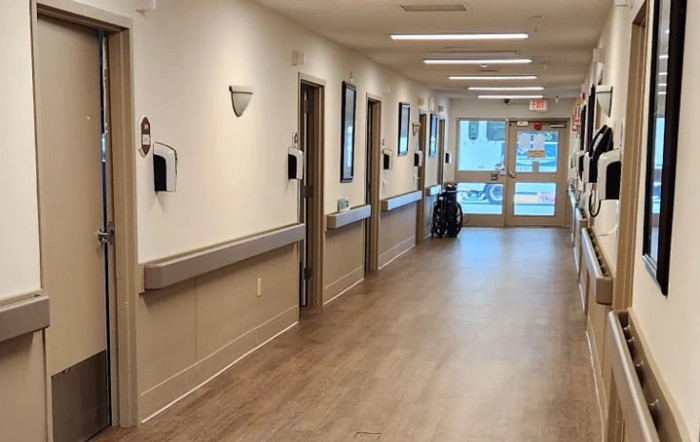 A clean and empty hospital hallway with several doors leading to medical rooms.