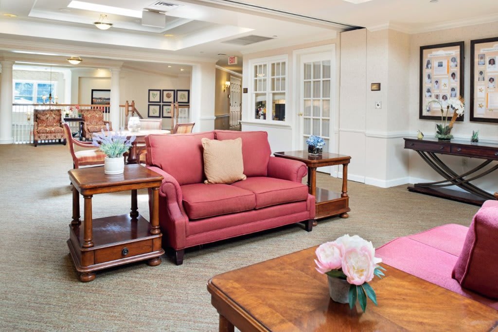 A cozy living room with a red sofa, coffee tables, and elegant decor.