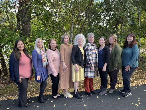 A group of women enjoying a beautiful day outdoors, standing together in a picturesque setting.