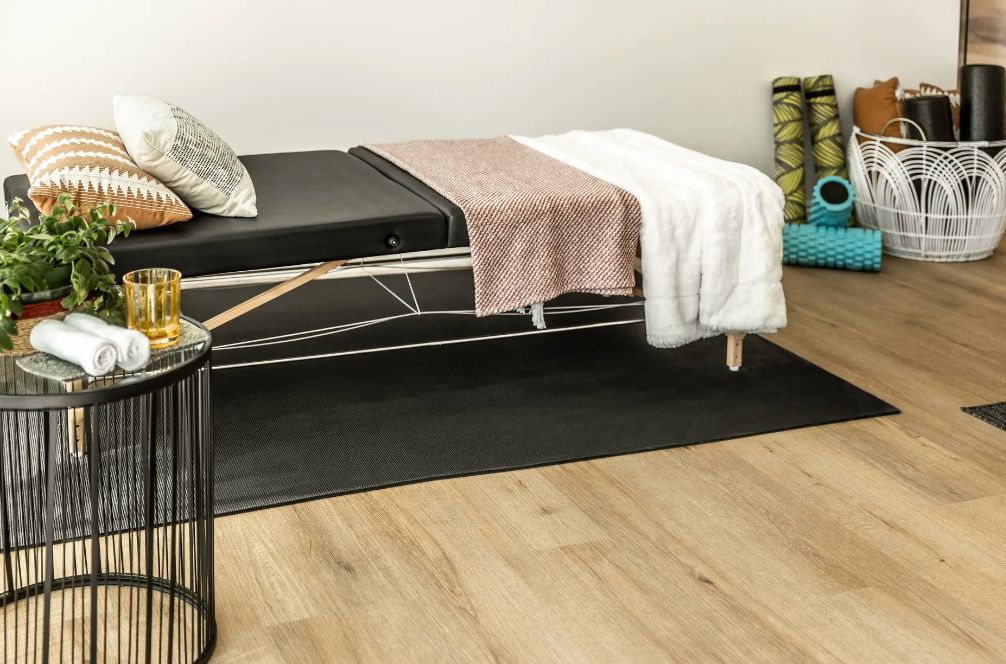 A serene therapy room featuring a massage table with cozy blankets and pillows.