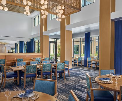 An elegant restaurant interior featuring blue chairs and modern lighting.