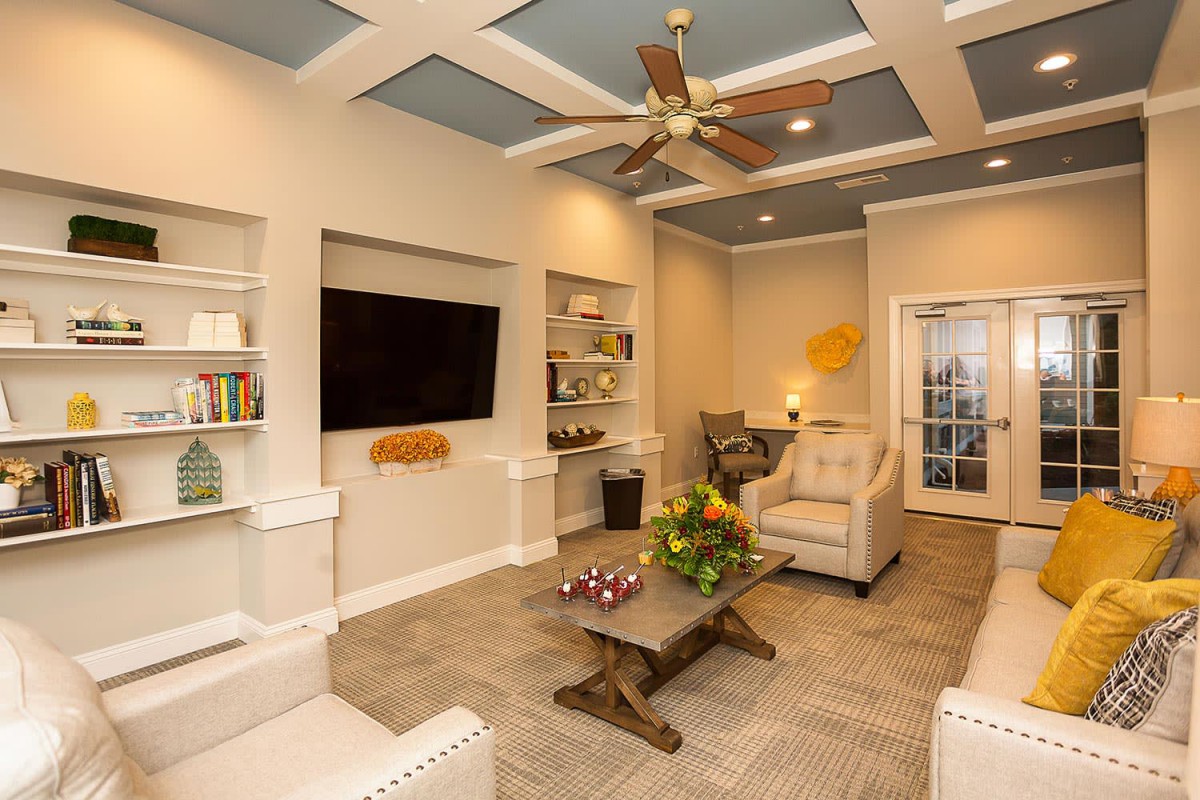 A modern and cozy living room with a large television, comfortable seating, and stylish decor.